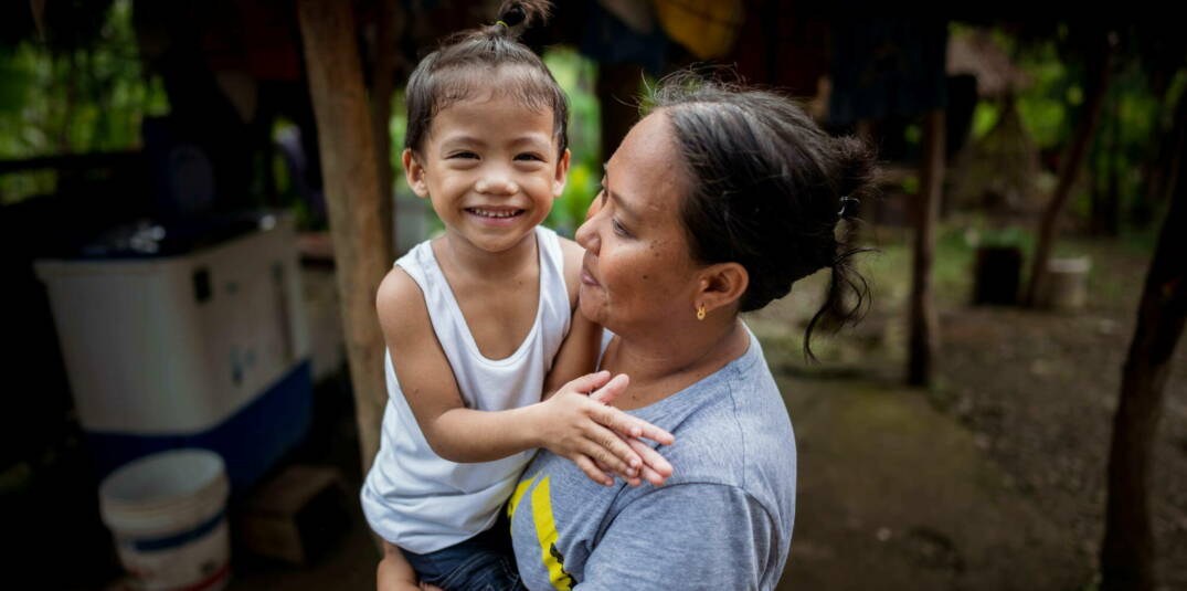 Eine Mutter trägt ihr kleines Kind auf dem Arm auf den Philippinen